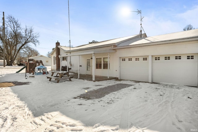 view of front facade featuring a playground and a garage