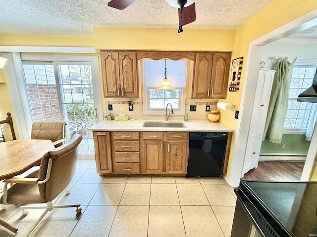 kitchen featuring sink, decorative light fixtures, a healthy amount of sunlight, and black appliances