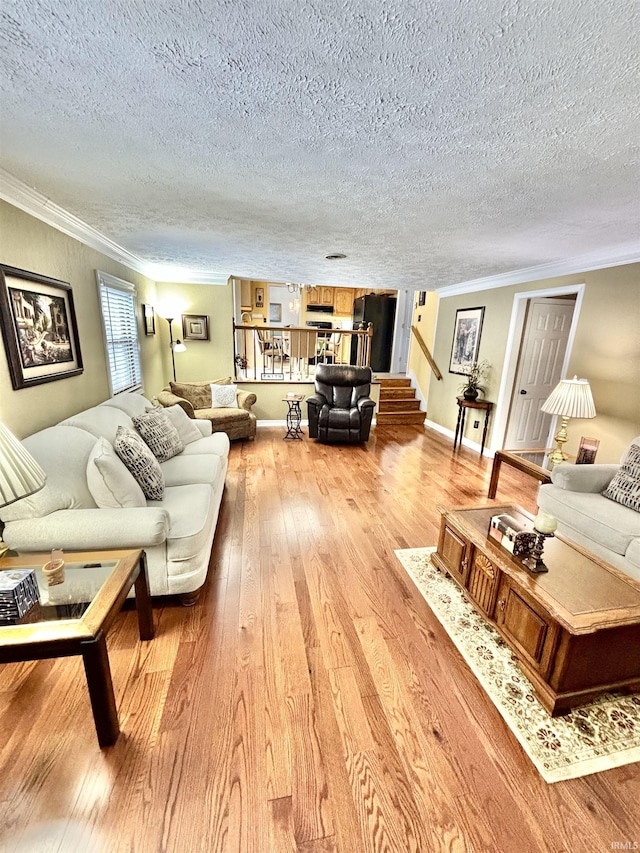 living room featuring light hardwood / wood-style floors, crown molding, and a textured ceiling