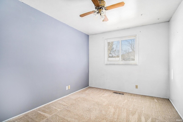 empty room featuring ceiling fan and carpet