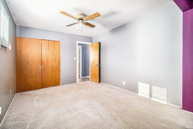 unfurnished bedroom featuring ceiling fan, a closet, and carpet