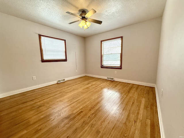 empty room featuring a textured ceiling, ceiling fan, and light hardwood / wood-style flooring