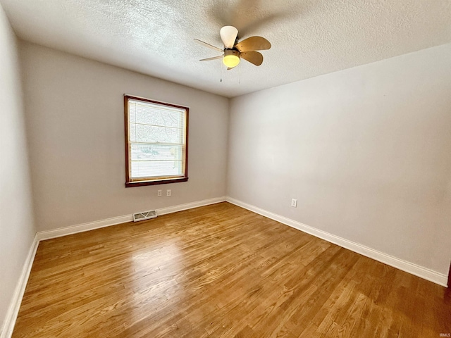 spare room featuring a textured ceiling, ceiling fan, and hardwood / wood-style floors