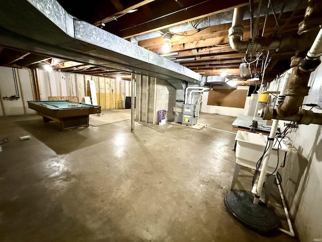 basement featuring pool table and heating unit