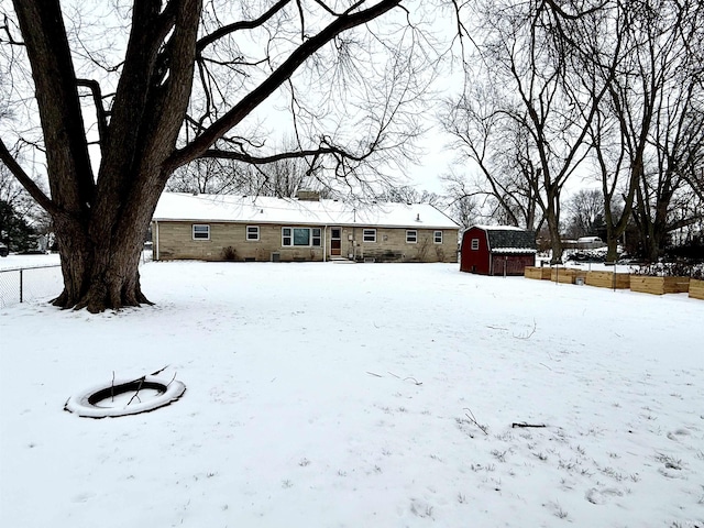 snowy yard with a shed