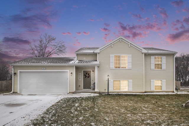 tri-level home featuring a yard and a garage