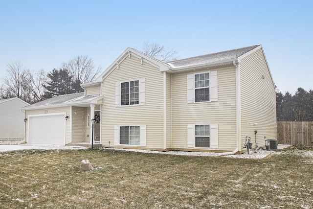 view of front of home featuring a front yard, a garage, and central air condition unit