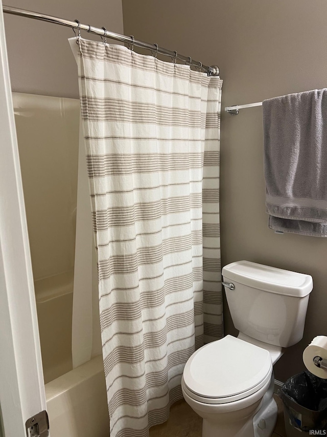 bathroom featuring toilet and shower / bath combo with shower curtain