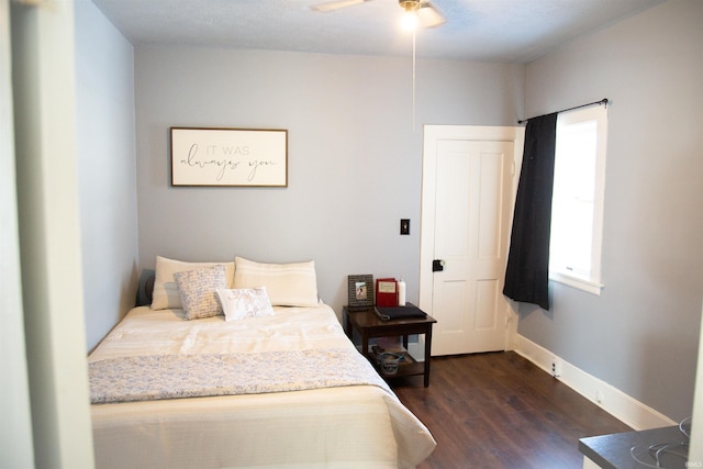 bedroom with ceiling fan and dark wood-type flooring