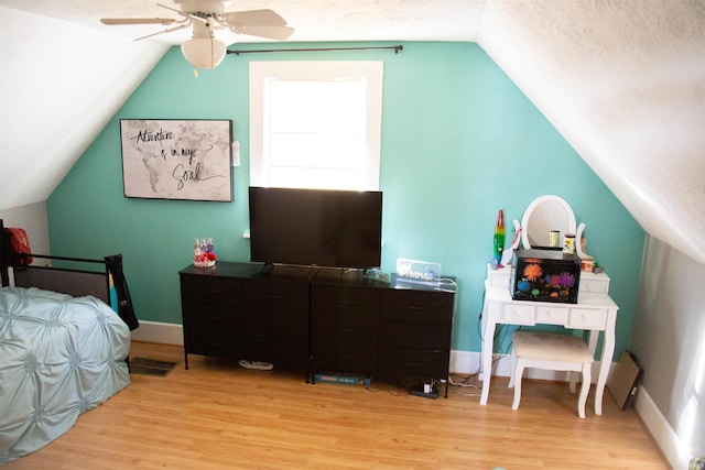 bedroom with ceiling fan, a textured ceiling, and light wood-type flooring