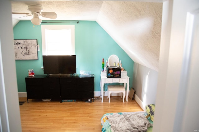 interior space featuring a textured ceiling, ceiling fan, lofted ceiling, and wood-type flooring