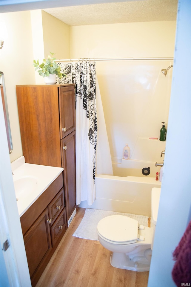 full bathroom featuring toilet, vanity, shower / bath combo with shower curtain, and hardwood / wood-style flooring