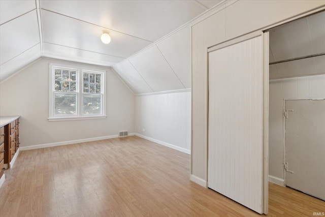 additional living space featuring light hardwood / wood-style flooring and lofted ceiling