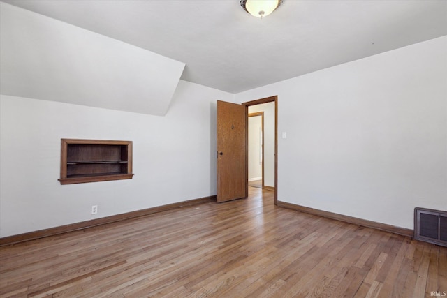 additional living space with light hardwood / wood-style flooring