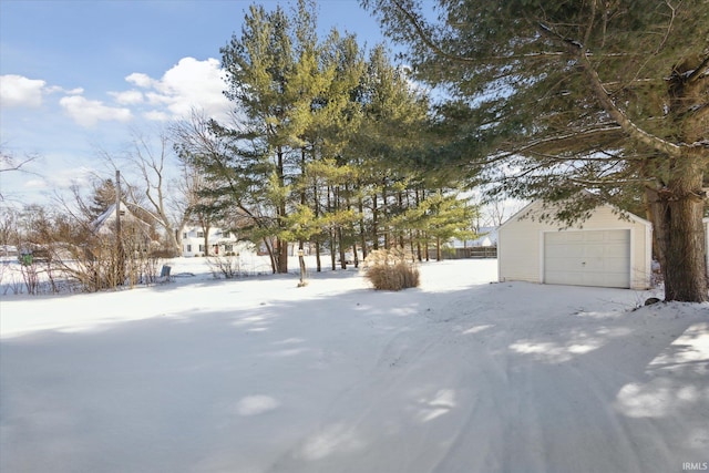 snowy yard with a garage