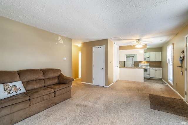 living room with ceiling fan, light colored carpet, and a textured ceiling