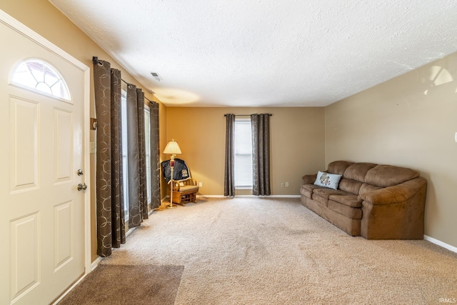 carpeted living room featuring a textured ceiling