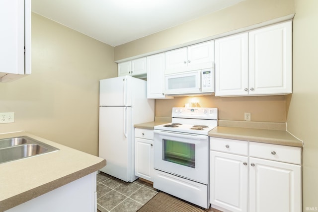 kitchen featuring sink, white appliances, and white cabinetry