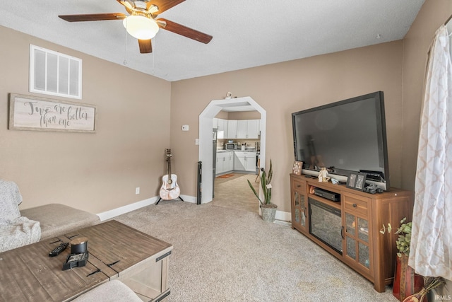 carpeted living room with ceiling fan