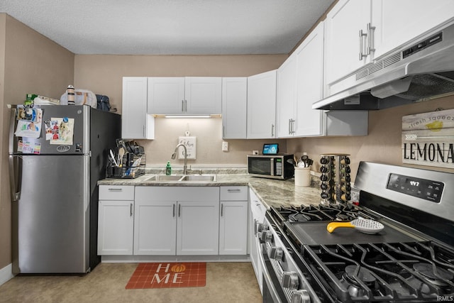 kitchen with light stone countertops, sink, white cabinetry, and stainless steel appliances