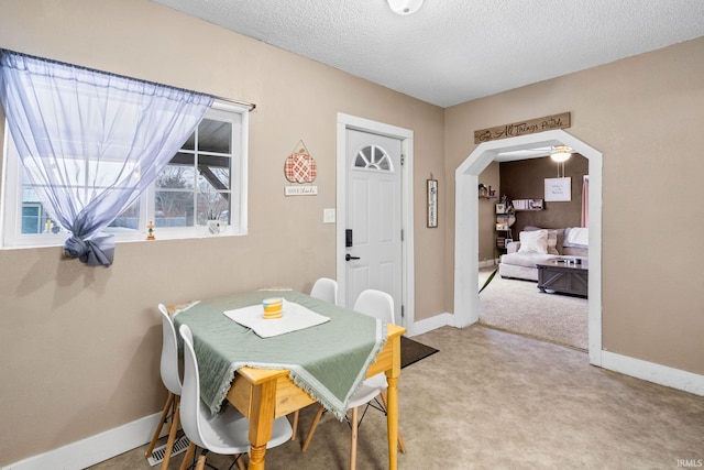 carpeted dining area featuring a textured ceiling and ceiling fan