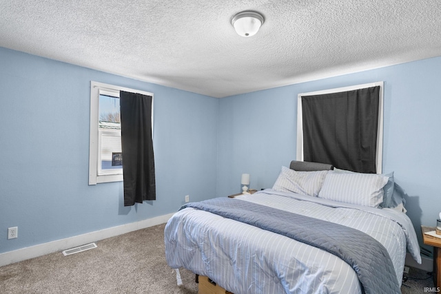 carpeted bedroom with a textured ceiling