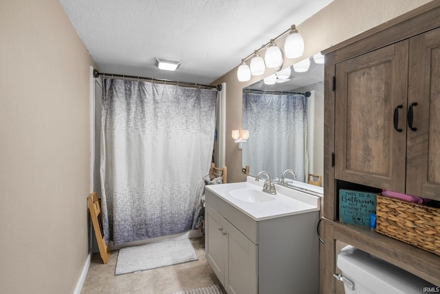 bathroom featuring a textured ceiling, toilet, vanity, and walk in shower