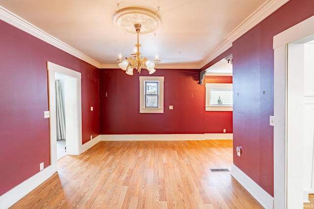 unfurnished room featuring light wood-type flooring, ornamental molding, and an inviting chandelier