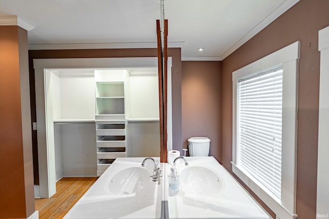 bathroom with wood-type flooring, toilet, vanity, and ornamental molding