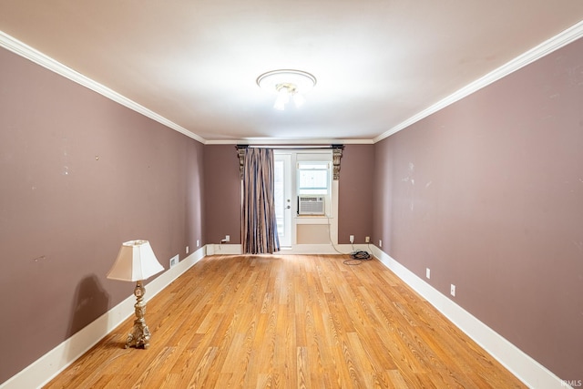 empty room with cooling unit, ornamental molding, and light wood-type flooring