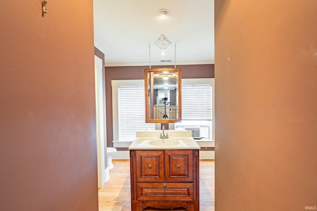 bathroom featuring toilet, ornamental molding, vanity, and a wall mounted air conditioner