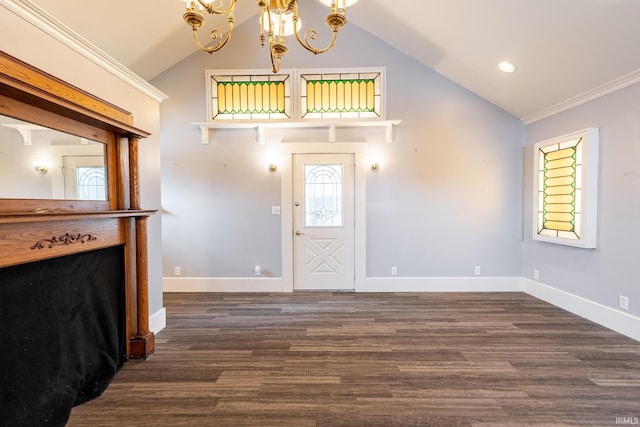 entrance foyer with lofted ceiling, dark hardwood / wood-style floors, an inviting chandelier, and crown molding