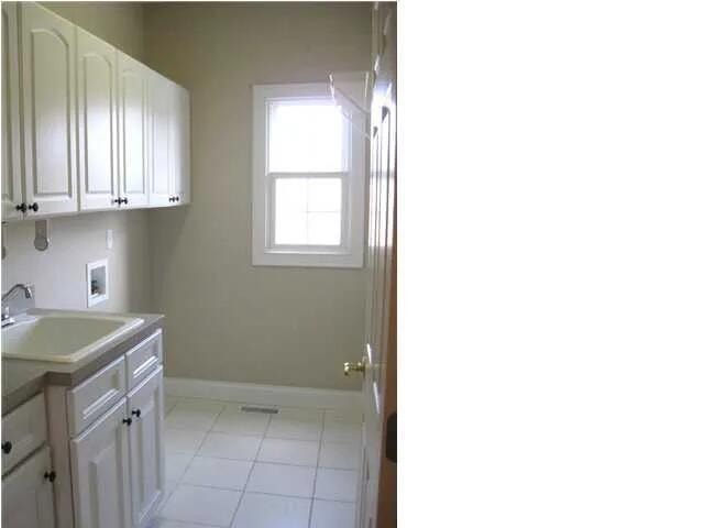 laundry area with cabinets, washer hookup, light tile patterned floors, and sink