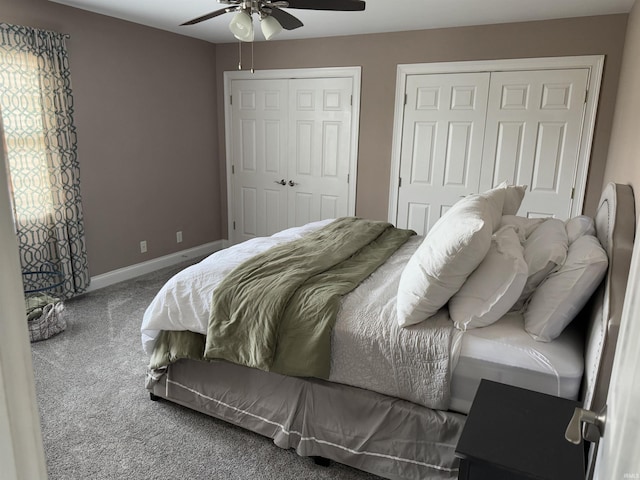 bedroom with ceiling fan, carpet floors, and two closets