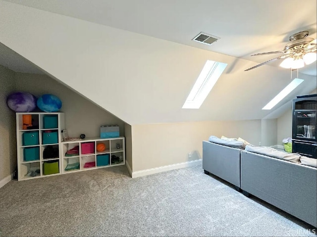 additional living space featuring carpet floors, vaulted ceiling with skylight, and ceiling fan