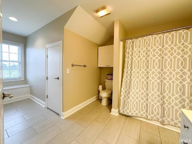 bathroom featuring lofted ceiling and toilet