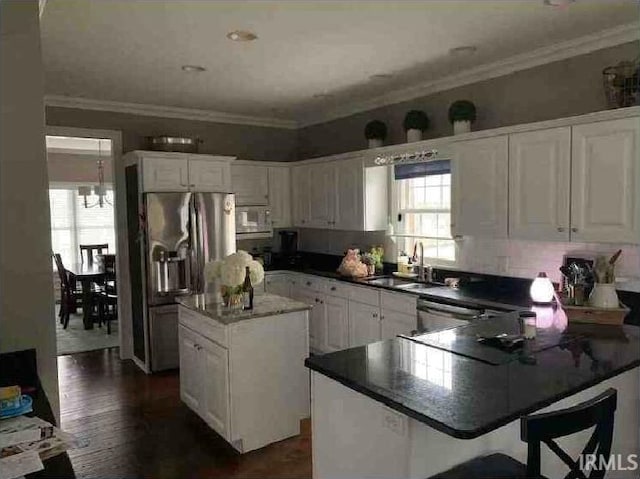 kitchen featuring stainless steel appliances, a kitchen island, and white cabinets