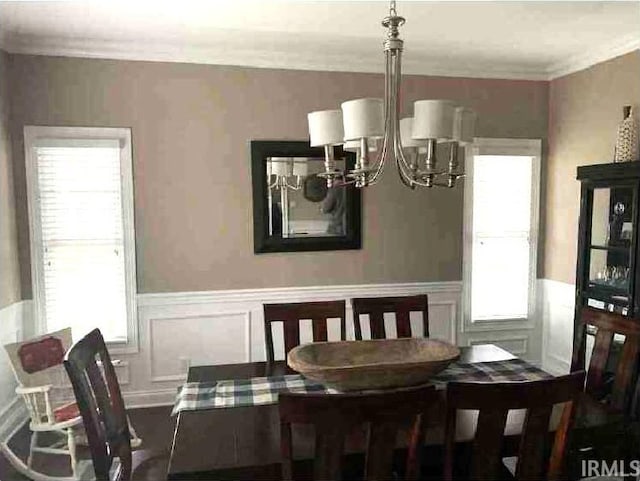 dining room featuring crown molding, plenty of natural light, and a notable chandelier