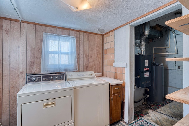 washroom with independent washer and dryer, wooden walls, water heater, and a textured ceiling