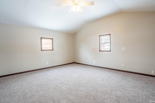 spare room featuring ceiling fan, a wealth of natural light, carpet, and lofted ceiling