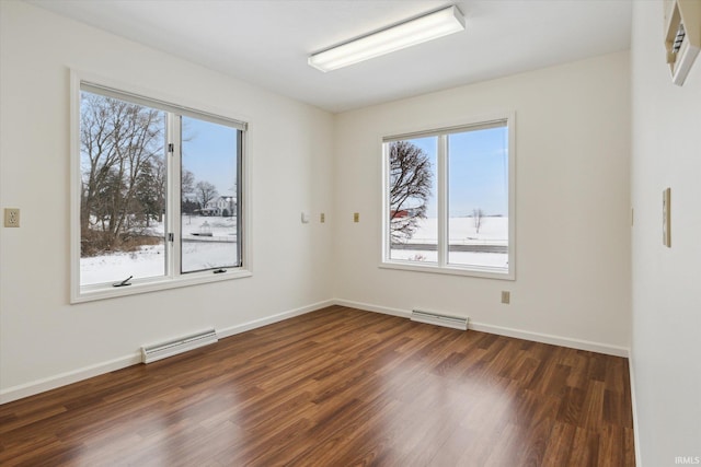 spare room with a wealth of natural light and dark hardwood / wood-style flooring