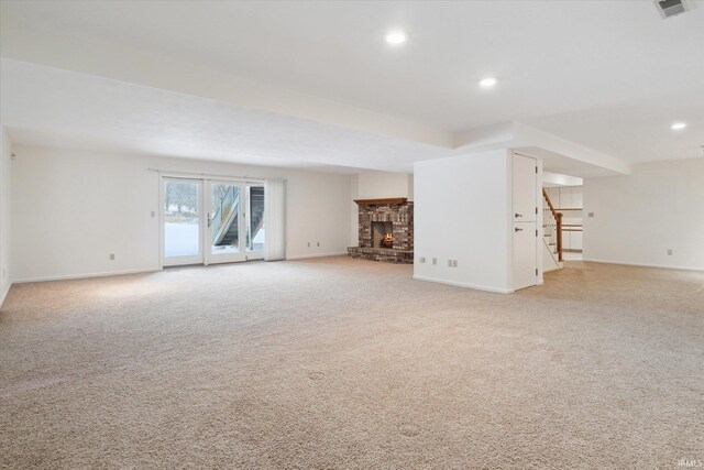 unfurnished living room with light colored carpet and a fireplace