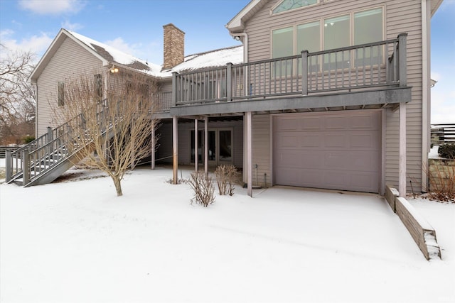 snow covered property with a garage