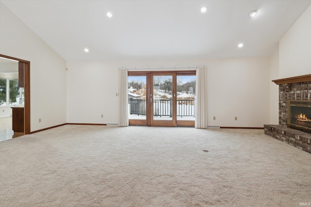 unfurnished living room with a fireplace, light colored carpet, and vaulted ceiling