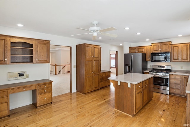 kitchen with ceiling fan, appliances with stainless steel finishes, light hardwood / wood-style flooring, and a center island