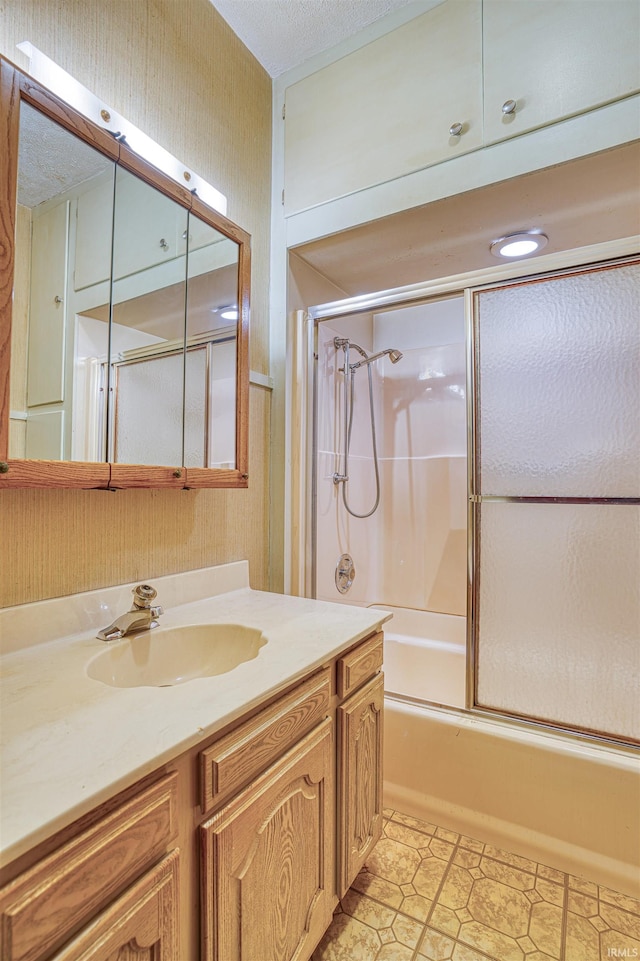 bathroom featuring bath / shower combo with glass door and vanity