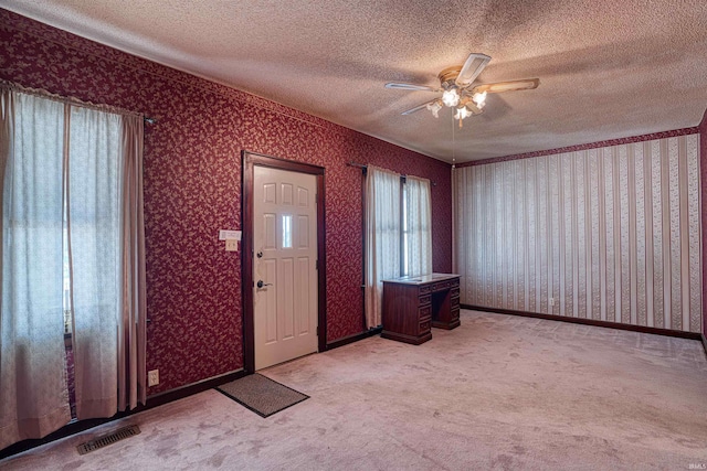 interior space with ceiling fan, light colored carpet, and a textured ceiling