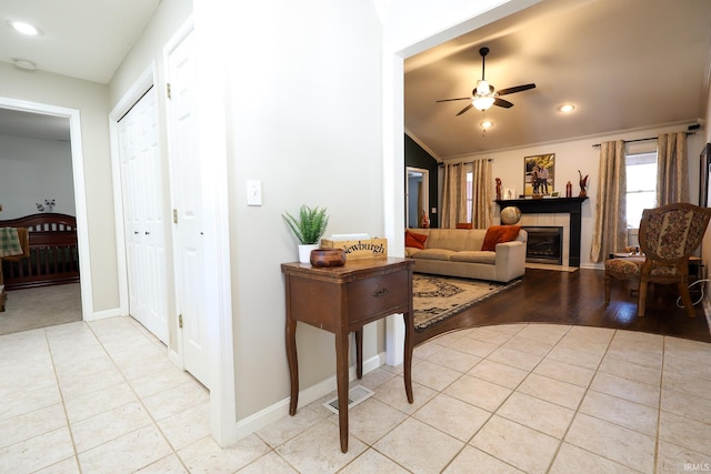 living room featuring ceiling fan, crown molding, and light tile patterned flooring