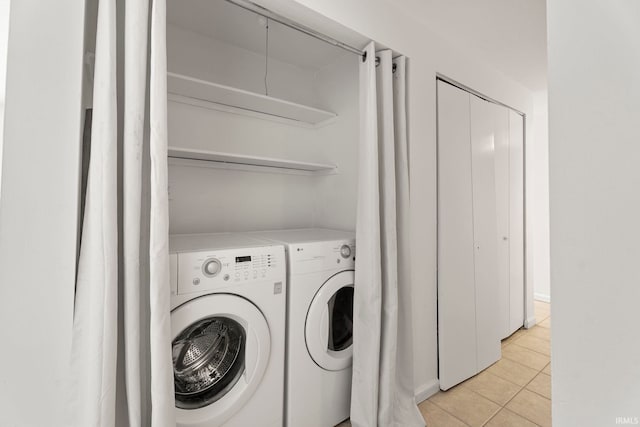 laundry room featuring light tile patterned floors and washing machine and clothes dryer