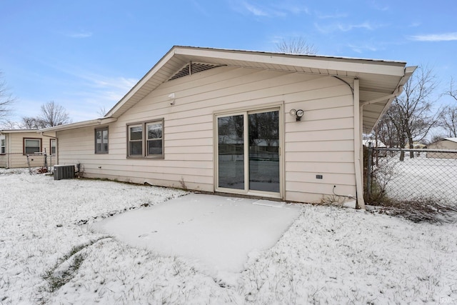 snow covered back of property featuring cooling unit